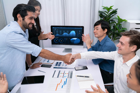 Analyst team leader shake hand with his colleague after successful data analysis meeting using...