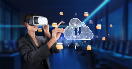 A businesswoman engages with virtual reality technology to manage cloud data in a modern workspace,...
