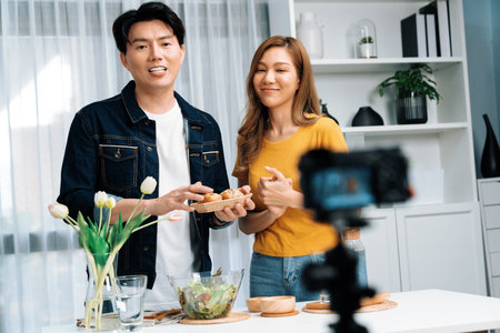 Cooking show on live streaming with two chef influencers presenting wholegrain bun bread side dish with mix salad preparing ingredients with dressing for easy special menu record by camera.の写真素材