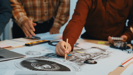 Engineers engage in a detailed design meeting, using technical drawings and precision tools. The environment captures creativity and collaboration in a modern workspace.の写真素材