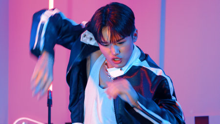 Close up of asian street dancer practicing street dancing at studio with purple led light. Professional performer perform energetic movement with stylish cloth. Half body.の写真素材