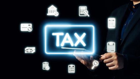 A professional holding a smartphone featuring a glowing tax sign. Surrounding icons symbolize finance, accounting, and digital documentation on a dark backdrop.の写真素材