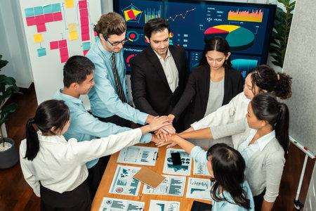 Multiracial business people make synergy hand stack together in meeting room as cooperation or team building for corporate employee in workplace.の写真素材
