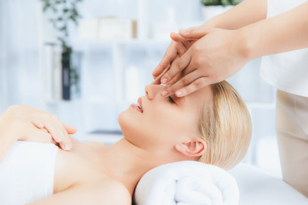 Caucasian woman enjoying relaxing anti-stress head massage and pampering facial beauty skin recreation leisure in dayspa modern light ambient at luxury resort or hotel spa salon. Quiescentの写真素材
