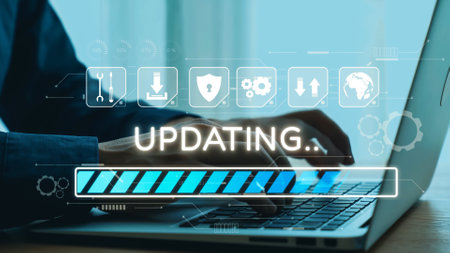 A close-up of hands typing on a laptop keyboard with a progress bar labeled updating displayed...