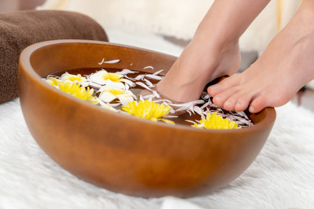 Woman indulges in blissful foot massage at luxurious spa salon while masseur give reflexology therapy in gentle day light ambiance resort or hotel foot spa. Quiescentの写真素材