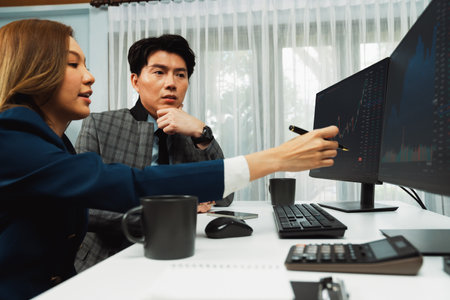 Asian business partners pointing to profit highest dynamic stock exchange data on computer screen value rate online website program. Investor showing financial on real time at modern office. Infobahn.の写真素材