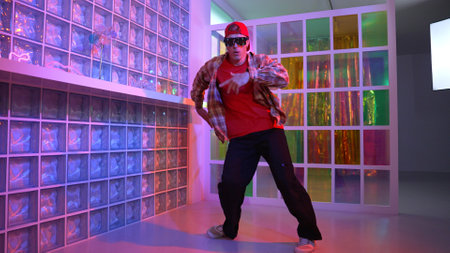 Funny break dancer moving freestyle step to hiphop while looking at camera. Crazy happy hipster dancing and performing street dancing while wear casual outfit and sunglasses in Led light. Regalement.の写真素材