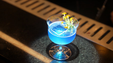Closeup beautiful mixed blue hawaii cocktail decorated with flower at luxurious counter bar perfect...