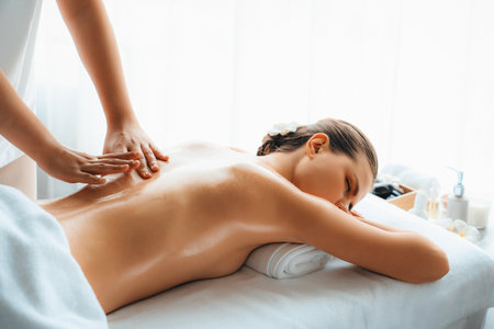 Caucasian woman customer enjoying relaxing anti-stress spa massage and pampering with beauty skin recreation leisure in day light ambient salon spa at luxury resort or hotel. Quiescentの写真素材