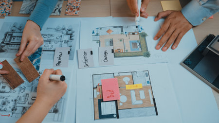 Dynamic scene showcasing multiple hands working together on interior design plans, featuring...