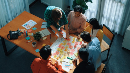 Top view of business people hands making scrum task board to manage workflow in workplace. Diverse marketing team writing sticky notes while working on kanban. Creative startup project. Directorate.の写真素材