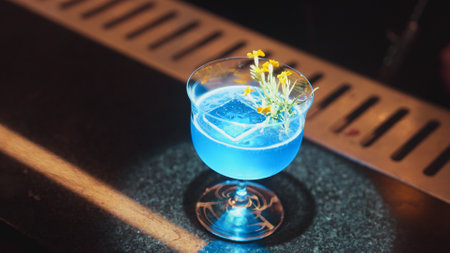 Closeup beautiful mixed vodka blue hawaii cocktail decorated with flower at luxurious counter bar perfect for advertisement in vibrant color presentation highlight atmosphere at nightclub.の写真素材