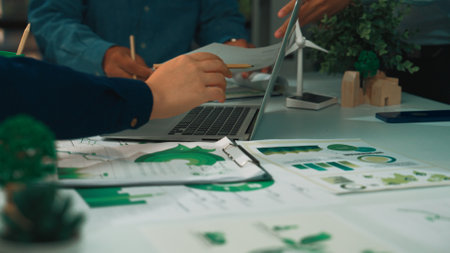 A modern office scene showcases a collaborative meeting focused on sustainability and green...