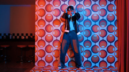 Asian break dancer moving to freestyle music and looking at camera at stage with balloon background. Professional hipster wearing casual outfit and fancy glasses while perform footstep. Regalement.の写真素材