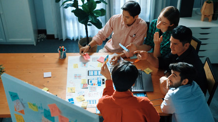 Top down view of business team putting hand together while discussing about Ux Ui design for mobile...