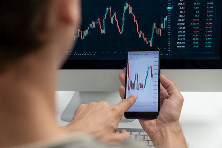 Smart stock investors pointing on screen with smartphone for market stock exchange along with laptop...