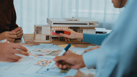 A vibrant collaboration scene featuring architects working on sketches and a detailed model,...