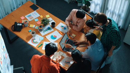 Top down view of multicultural business group putting hand together to celebrate increasing sales or...
