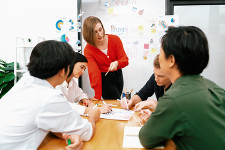 Happy cooperative multi-ethnic business group brainstorming discussion about marketing plan by using...