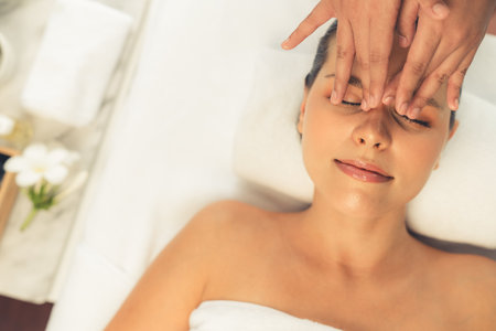 Panorama top view of woman enjoying relaxing anti-stress head massage and pampering facial beauty skin recreation leisure in dayspa modern light ambient at luxury resort or hotel spa salon. Quiescentの写真素材