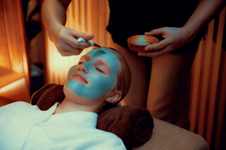 Serene ambiance of spa salon, woman customer indulges in rejuvenating with luxurious face cream massage with warm lighting candle. Facial skin treatment and beauty care concept. Quiescentの写真素材