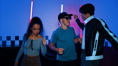 Diverse street dancer moving to city pop music at party with neon light while man wearing fancy...