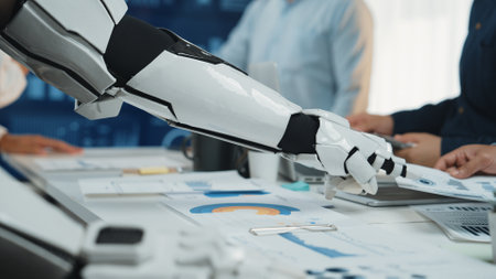 A robotic arm interacts with business professionals in a modern office, showcasing cutting-edge technology for collaboration and innovative solutions in data analysis.の写真素材