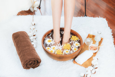 Woman indulges in blissful foot massage at luxurious spa salon while masseur give reflexology therapy in gentle day light ambiance resort or hotel foot spa. Quiescentの写真素材