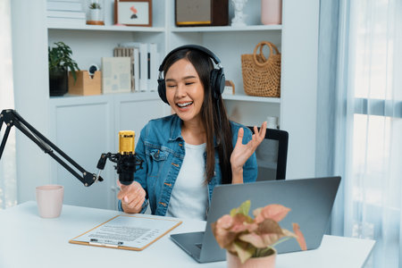 Host channel of young beautiful Asian wearing jeans creative broadcaster talking in online broadcast explaining to promote marketing or consultant in daily life with listener at studio. Stratagem.の写真素材