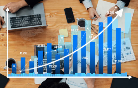 This image captures a busy business meeting with a detailed growth chart analysis. Various professionals are collaborating, showcasing trends and strategies in a modern office.の写真素材