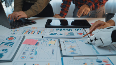 Business professionals analyze reports and charts in a collaborative office setting, focusing on data-driven decisions for strategic planning and growth.の写真素材