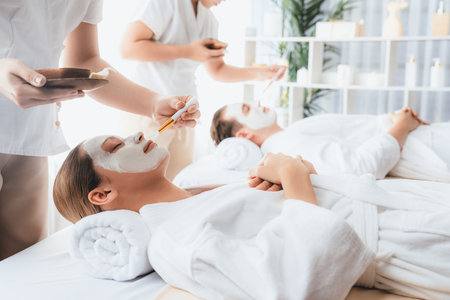 Serene ambiance of spa salon, couple indulges in rejuvenating with luxurious face cream massage with modern daylight. Facial skin treatment and beauty care concept. Quiescentの写真素材