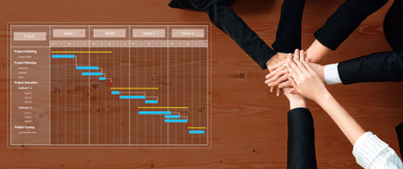 A top view of hands joining together over a Gantt chart highlighting project management phases,...