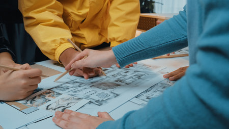 A collaborative scene featuring diverse designers intensely analyzing architectural blueprints and...