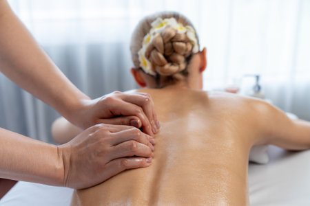 Caucasian woman customer enjoying relaxing anti-stress spa massage and pampering with beauty skin recreation leisure in day light ambient salon spa at luxury resort or hotel. Quiescentの写真素材
