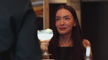 Smiling beautiful woman savoring tasty Margarita cocktail drink at luxurious bar creating moment...