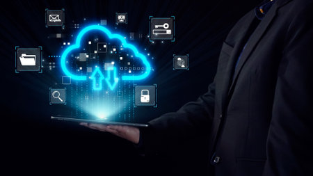 A person holding a tablet displays a glowing cloud icon, symbolizing data transfer and storage. This...