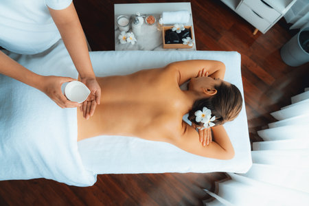 Panorama top view masseur hands pouring aroma oil on woman back. Masseuse prepare oil massage procedure for customer at spa salon in luxury resort. Aroma oil body massage therapy concept. Quiescentの写真素材
