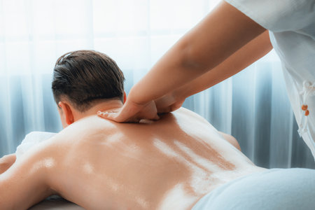 Caucasian man customer enjoying relaxing anti-stress spa massage and pampering with beauty skin recreation leisure in day light ambient salon spa at luxury resort or hotel. Quiescentの写真素材