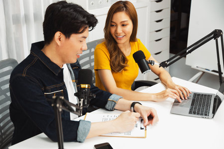 Smiling radio influencer hosts with channel social media online live streaming with talking topic...