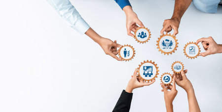 A diverse group of hands holds gears with business icons, symbolizing teamwork and collaboration in management concepts, enhancing productivity and innovation efforts.の写真素材