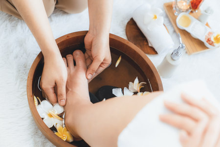 Woman indulges in blissful foot massage at luxurious spa salon while masseur give reflexology therapy in gentle day light ambiance resort or hotel foot spa. Quiescentの写真素材