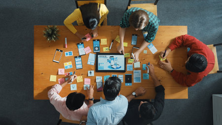 Top view of software developer team looking Ux Ui design for mobile phone interface from tablet...
