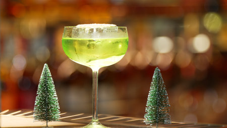 Special drink in Midori Sour cocktail with caramelized citrus slice served in stylish glass on luxurious bar decorated by christmas tree neon light theme on bokeh nightclub classic background.の写真素材