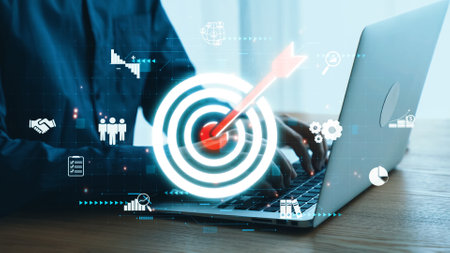 This image showcases a modern workspace featuring a laptop and digital target icons, symbolizing business growth, analytics, and strategic planning in a professional environment.の写真素材