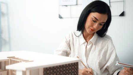 Closeup image of young architect engineer writing house structure in blueprint with document and...