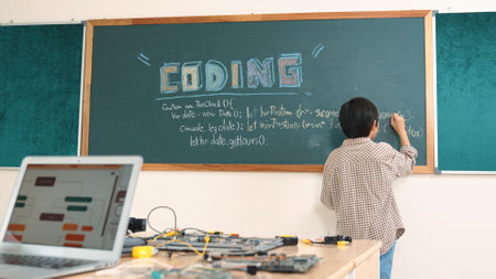 Girl writing engineering prompt by using AI software or programing system to generate AI on table with electronic main board at stem class while smart boy writing software development plan. Pedagogy.の写真素材