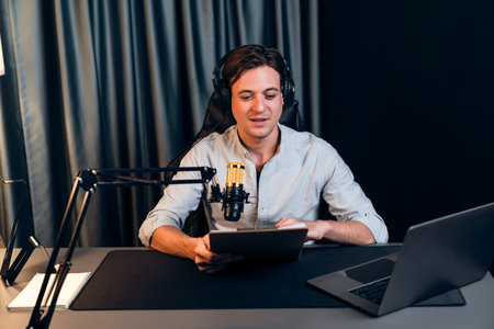Host channel in smart broadcaster with talking show on live social media streaming with script note reading to listener with record video streamer in warm light night time at modern studio.の写真素材