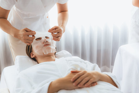 Serene modern daylight ambiance of spa salon, woman customer indulges in rejuvenating with facial skincare mask. Facial skin treatment and beauty cosmetology procedure for face. Quiescentの写真素材